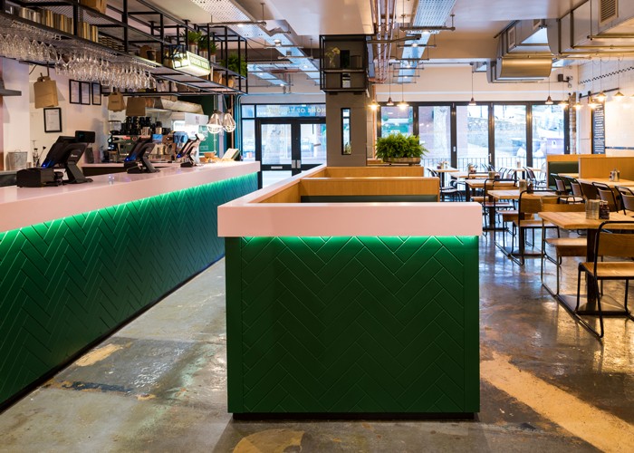 Web-8--Both-the-bar-and-the-external-surround-to-the-first-row-of-booth-seating-are-wrapped-in-green-herringbone-timber-with-a-pink,-LED-lit-Corian-top